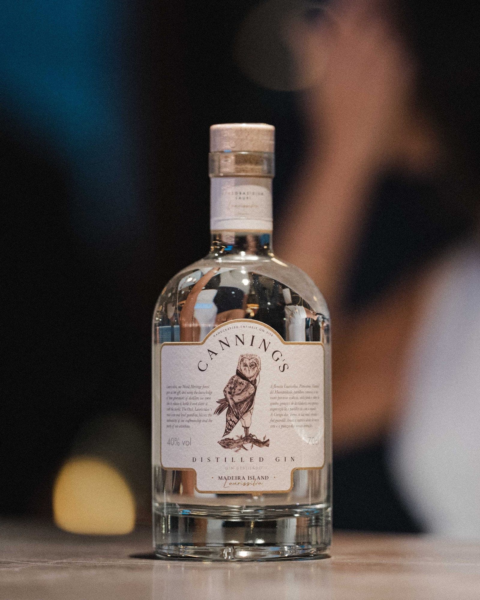 Uma garrafa de gin Canning's ao balcão, em luz quente e suave